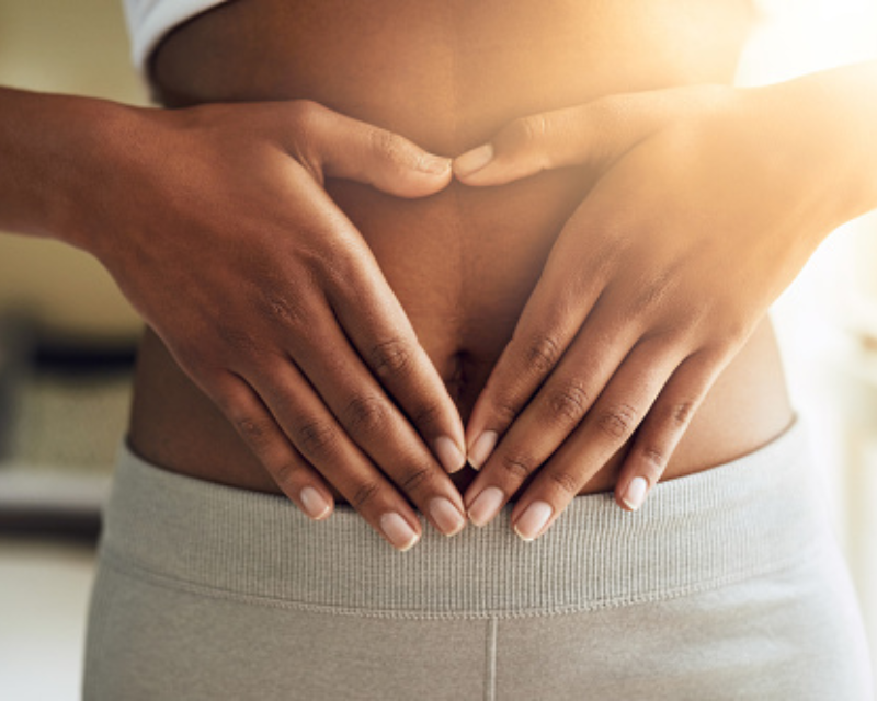 woman holding hands in heart by uterus