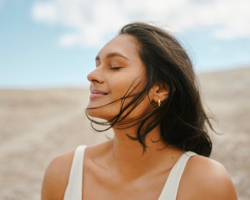 woman taking deep breath on the beach